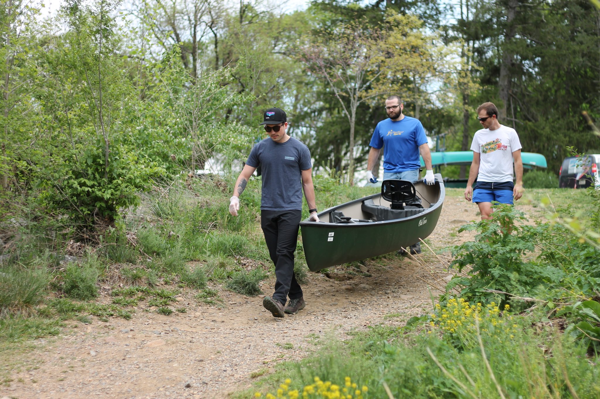 Volunteers from Carilion Clinic carry canoe to the river