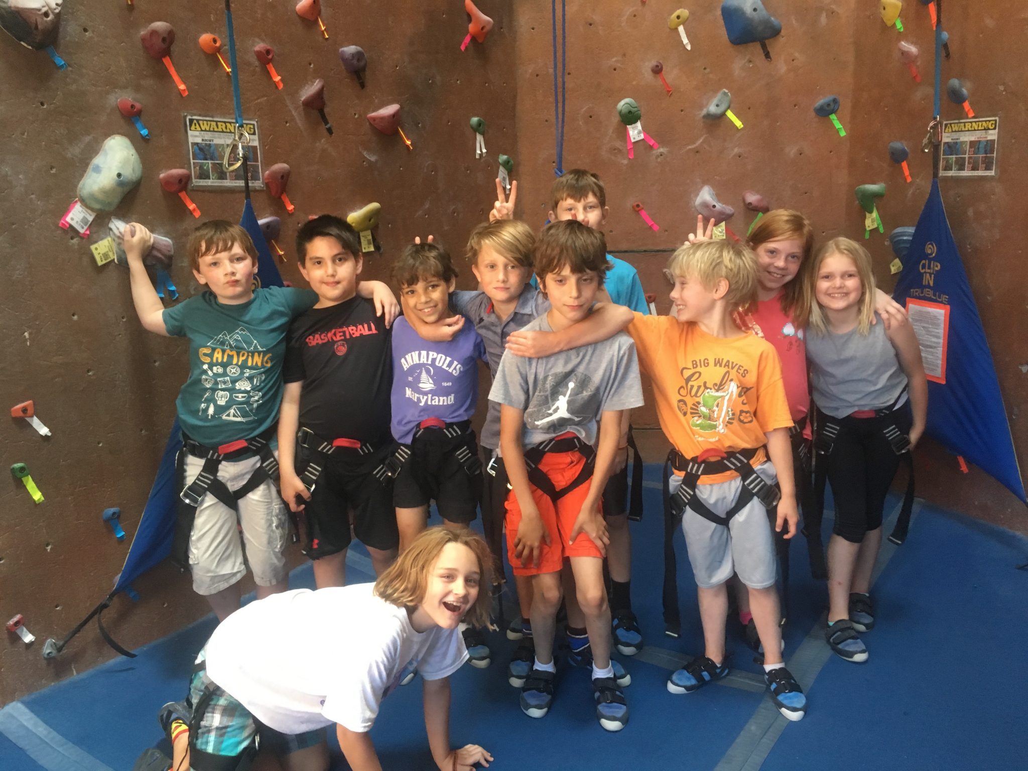 Kids smiling at indoor climbing wall