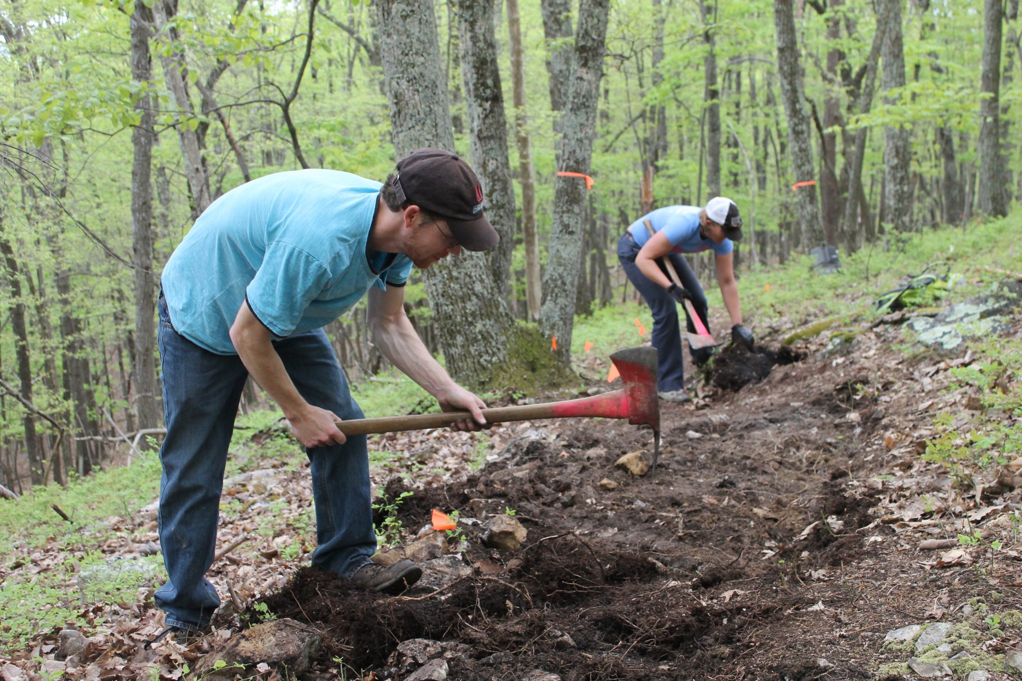 Mike and Renee build White man with ax building natural-surface trail in the woods