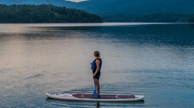 Person standing on stand up paddleboard on water of Carvins Cove