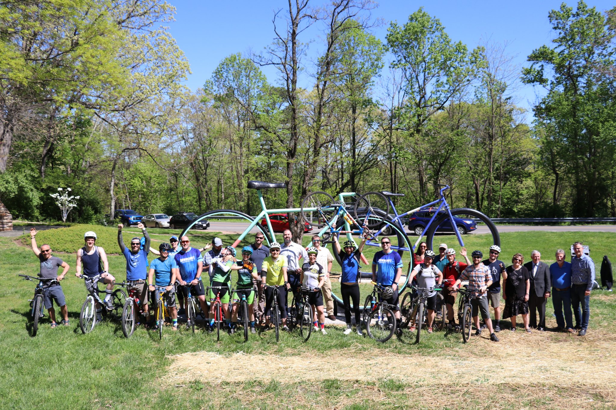 Group of people on bikes standing in front of two large bike statues