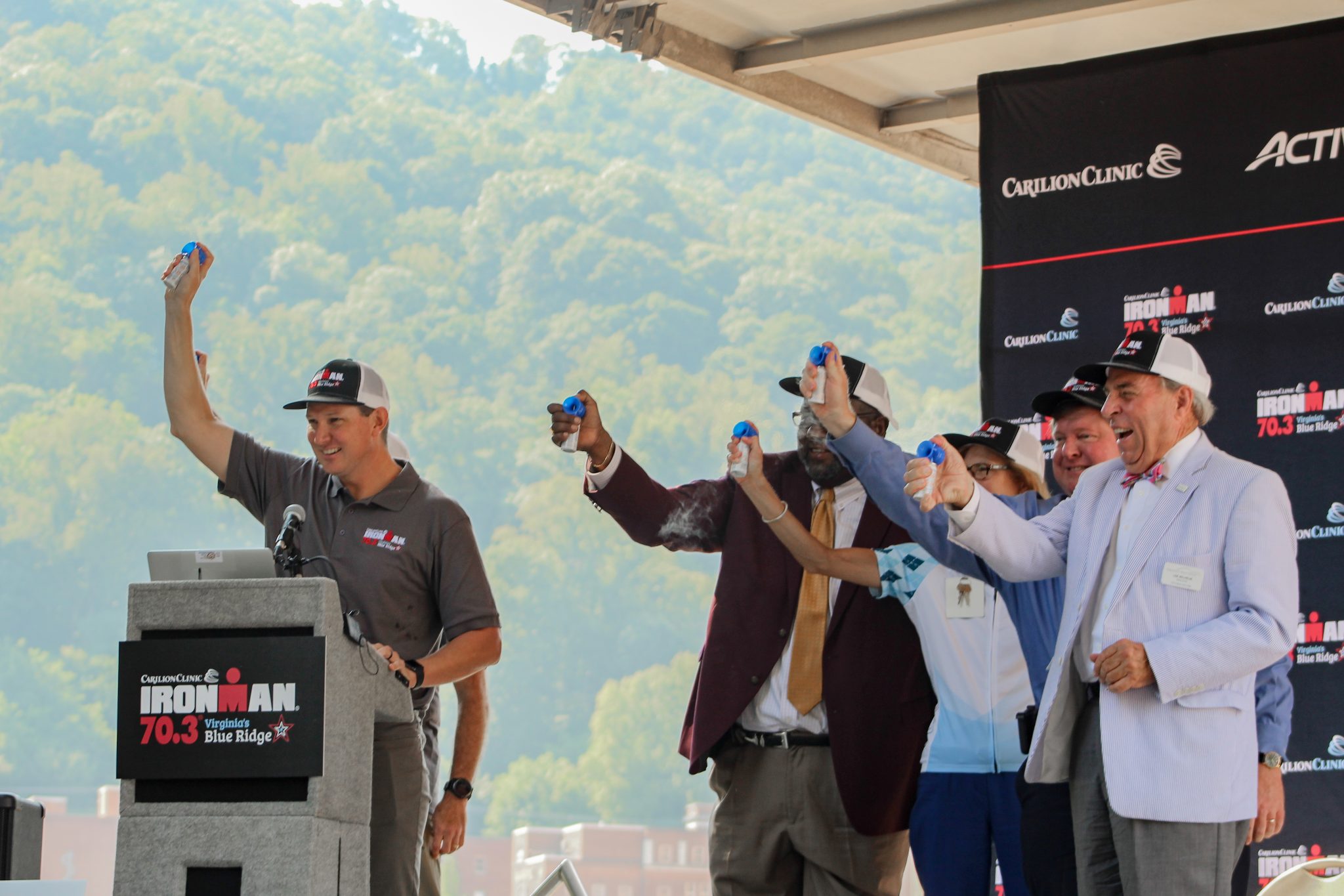 Race, Carilion, and City representatives sounding air horns on a stage.