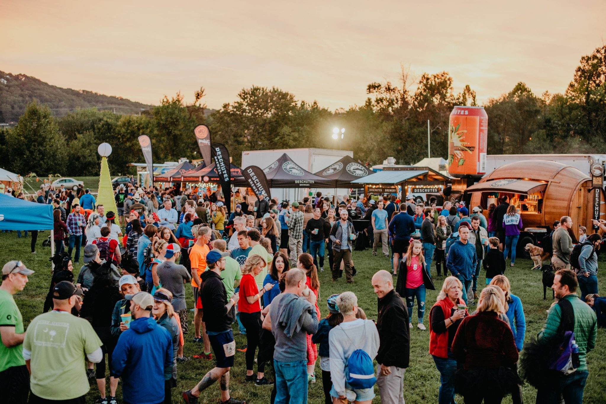 Crowd gathered for festival at park at sunset 