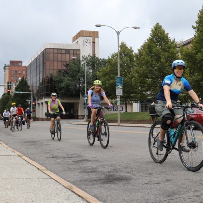 Several cyclists riding single file on a street