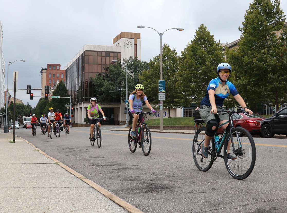 Several cyclists riding single file on a street