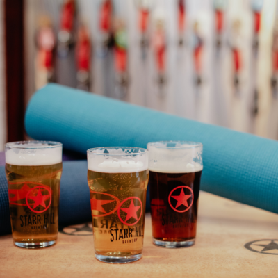 Glasses of beer with rolled up yoga mats in the background