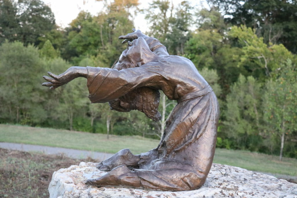 Sculpture of young woman bent backwards in the wind