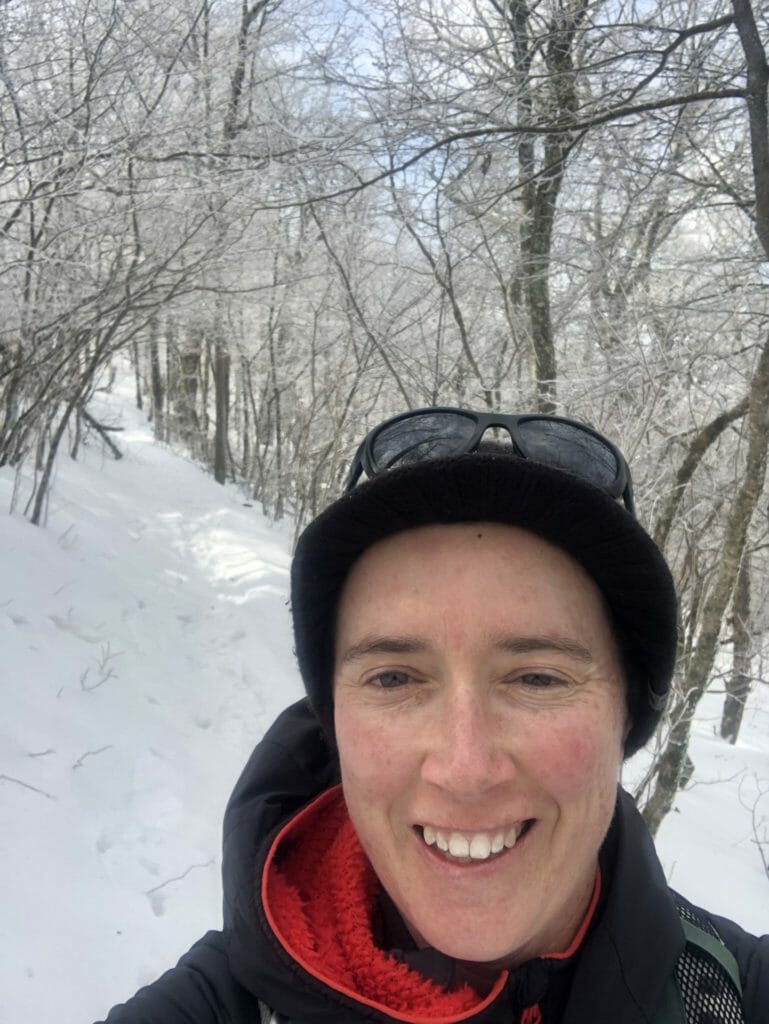 Woman smiling on a snowy trail