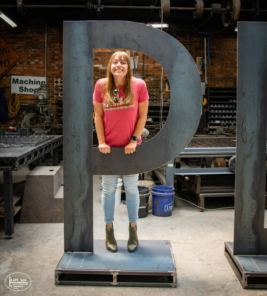 Woman smiling with a big letter "P"