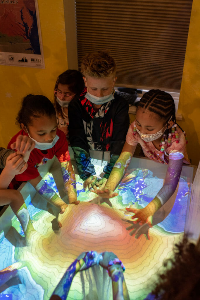 Children play with Augmented Reality Sandbox