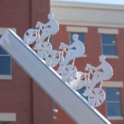 Sculpture representing mountain bikers climbing a hill