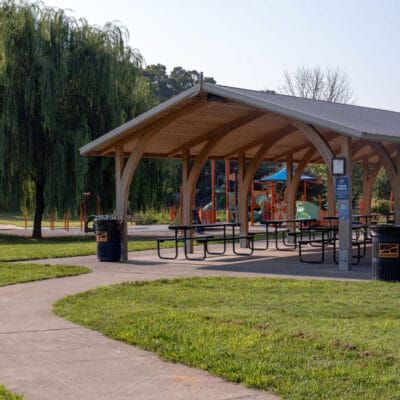 Countryside Park Park shelter with picnic tables, shade trees, and playground nearby