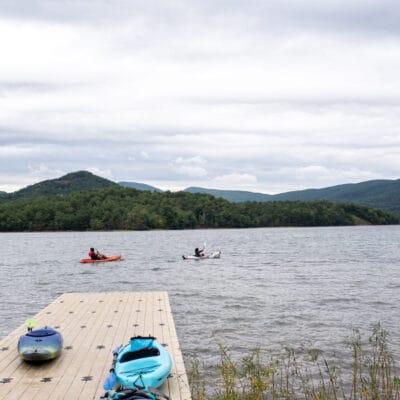 Paddling at Carvins Cove Two kayakers paddle by the floating dock at Carvins Cove, with mountains in the background