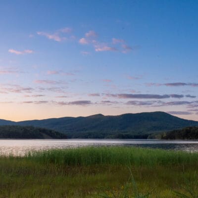 Carvins Cove at Sunset a a blue sky and pink clouds at sunset over the mountains at Carvins Cove reservoir