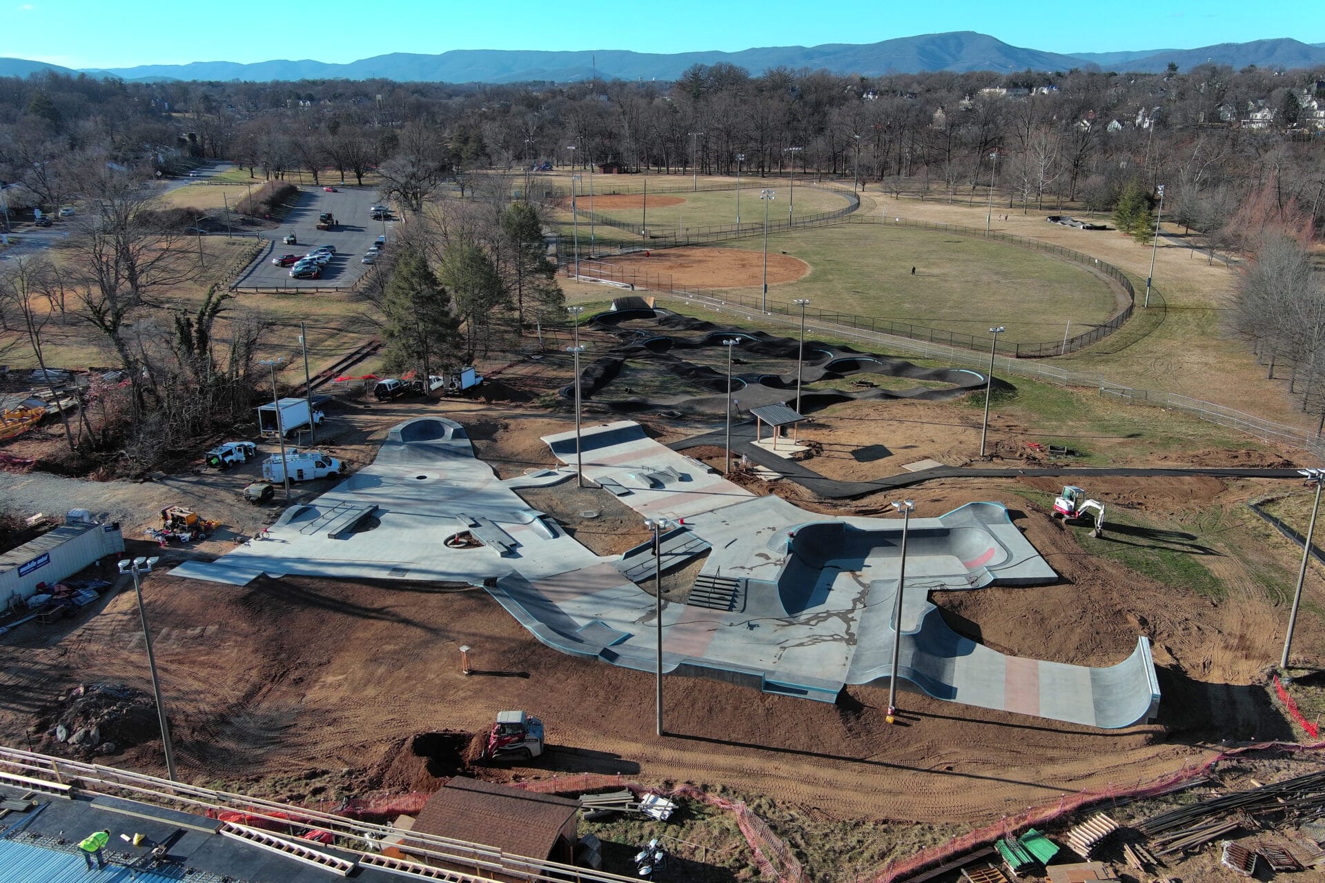 Aerial view of skatepark and pump track with ballfields in the distance.