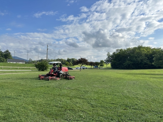mowing Large grass mower in a park.