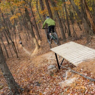 Mill Mountain Bike Trails - Devin Cutter A biker rides off a wooden ramp jump feature on downhill mountain bike trails on Mill Mountain.