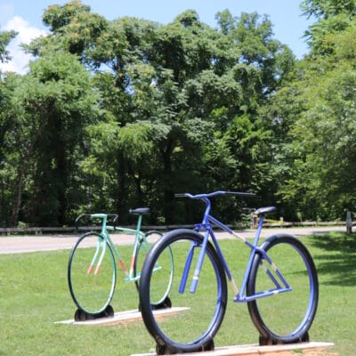 Big Ol' Bikes Two oversized bike sculptures in a grassy field.