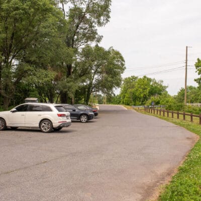 Parking lot at a greenway with portable toilet.