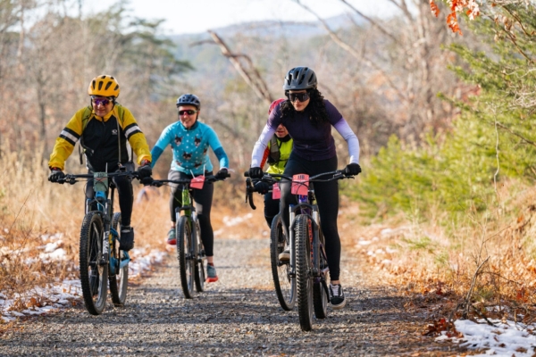 Happy Valley Grit A group of cyclists races on a gravel trail in winter.