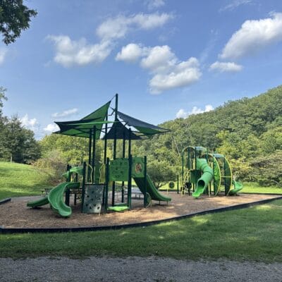 Fishburn Park Playground Playground in a park with woods and grassy fields surrounding it.