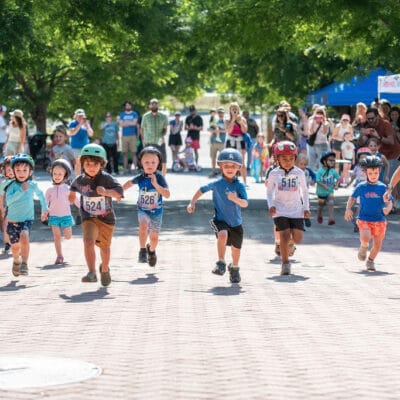 TinyTotTri26 885web A group of kids race in a park as part of a 'triathlon' event for toddlers and small children.