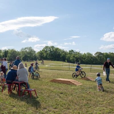 YouthMTBrace 846web Families and young children prepare for a kid's bike race in a city park.