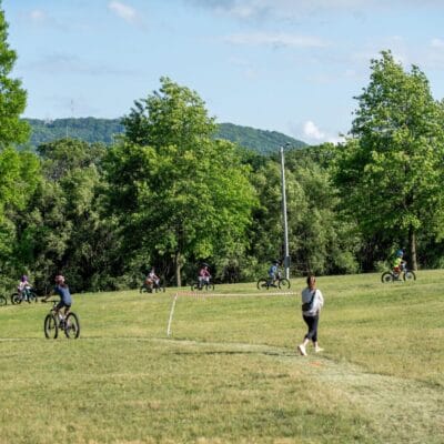 YouthMTBrace 868web A group of young mountain bikers compete in a race at a city park.