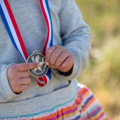 YouthMTBrace 869web A small child holds their medal from a kid's bike race.