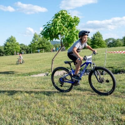 YouthMTBrace 876web Young mountain bikers compete in a race at a city park.
